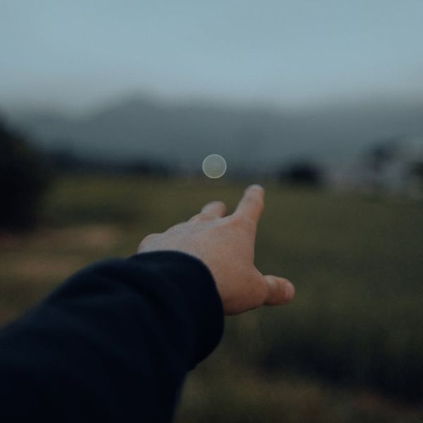 Person stretching outdoors with a serene landscape in the background.