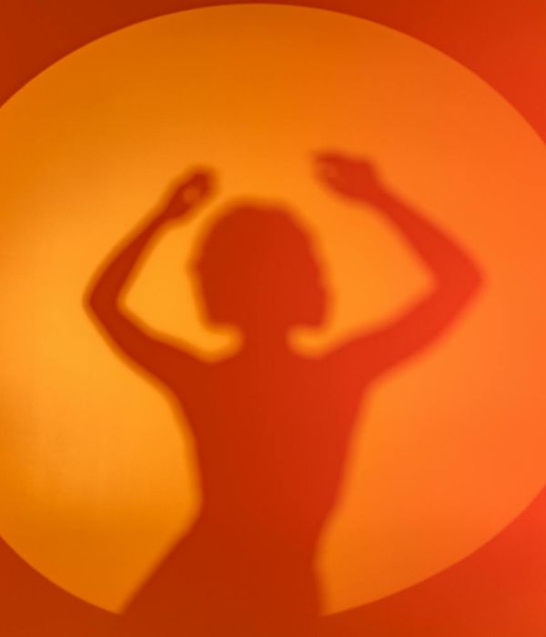 Woman performing a fluid cardio movement in a bright, minimalist studio.